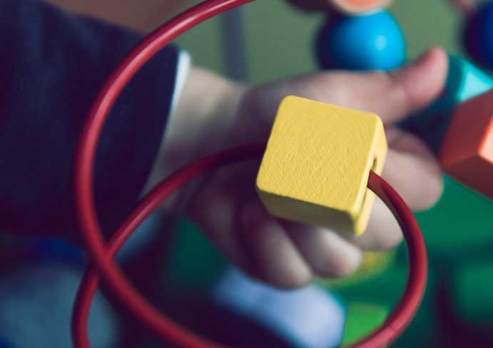 close-up of a child's hand playing with a block
