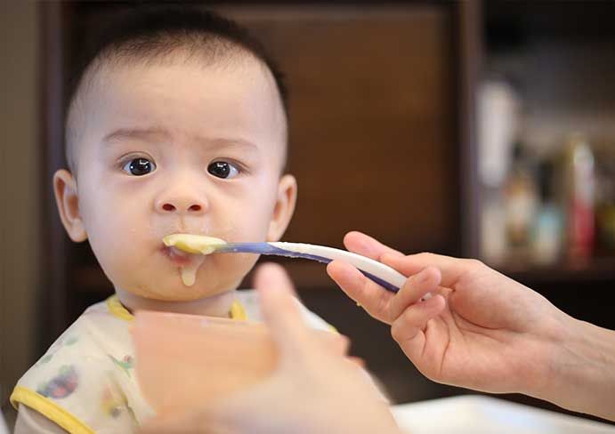 baby boy with soup on a spoon