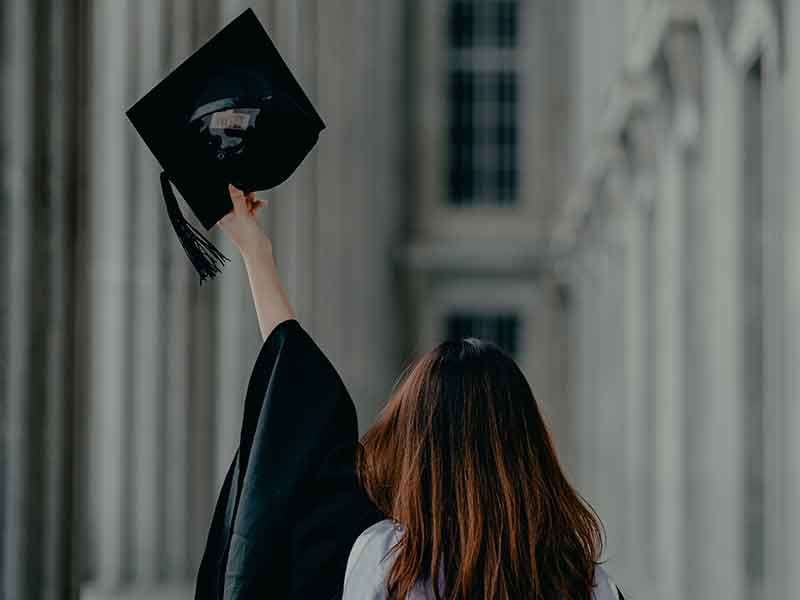  the student is waving her cap on the graduation day
