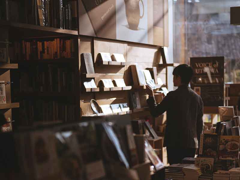 student browsing books in a bookstore